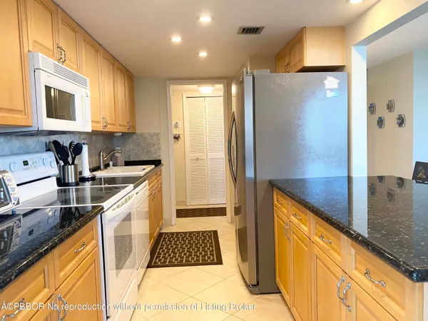 a kitchen with stainless steel appliances granite countertop a refrigerator and a stove
