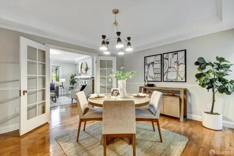 a view of a dining room with furniture wooden floor and chandelier