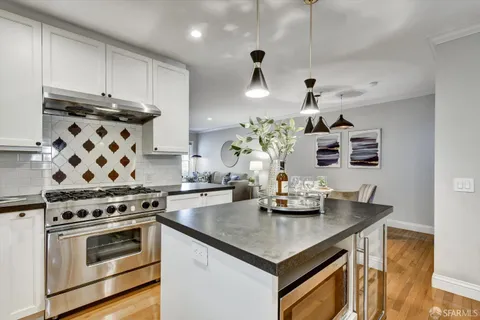 a kitchen with stainless steel appliances granite countertop a sink stove and cabinets