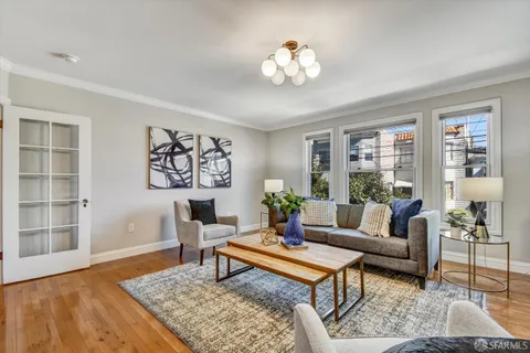 a living room with furniture a fireplace and wall mirror