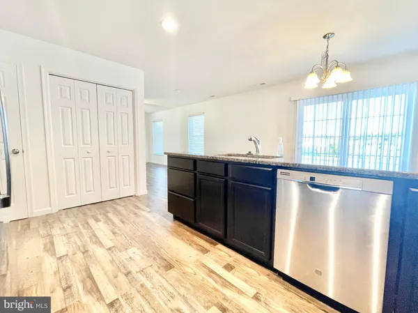 a view of a kitchen with a sink and wooden floor