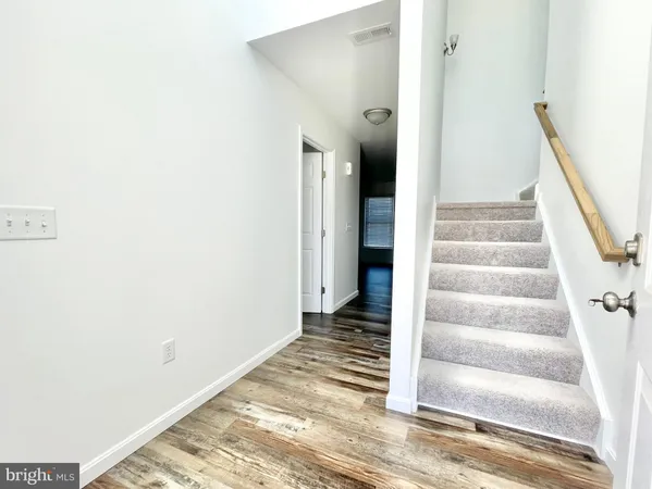 a view of a hallway with wooden floor and entryway