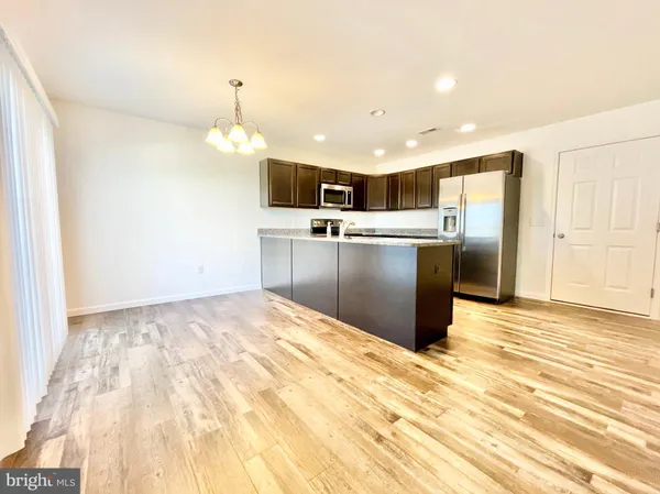 a kitchen with stainless steel appliances kitchen island a refrigerator sink and cabinets