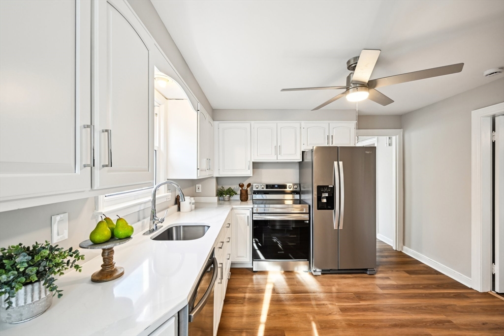 49 Dellwood Road Worcester, MA 01602 - Photo 14 of 27 a kitchen with stainless steel appliances granite countertop a refrigerator a stove a sink dishwasher and white cabinets with wooden floor