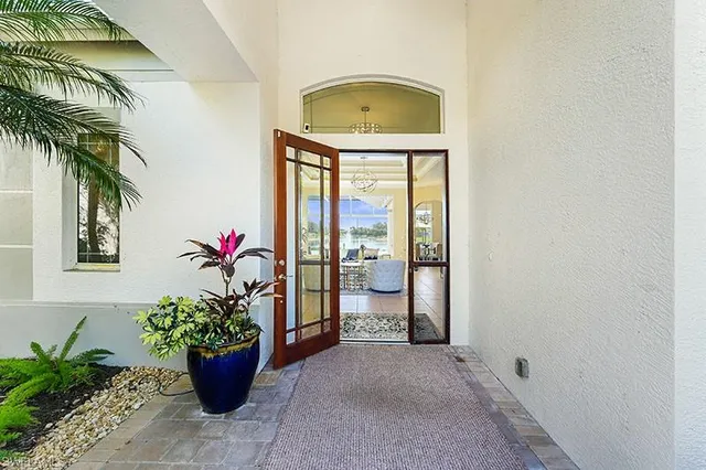 a vase with flowers sitting on a floor in front of a door