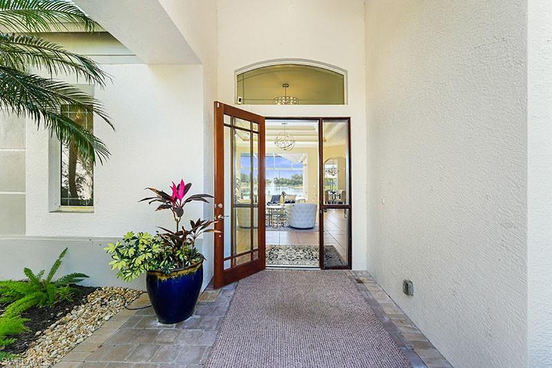 a vase with flowers sitting on a floor in front of a door