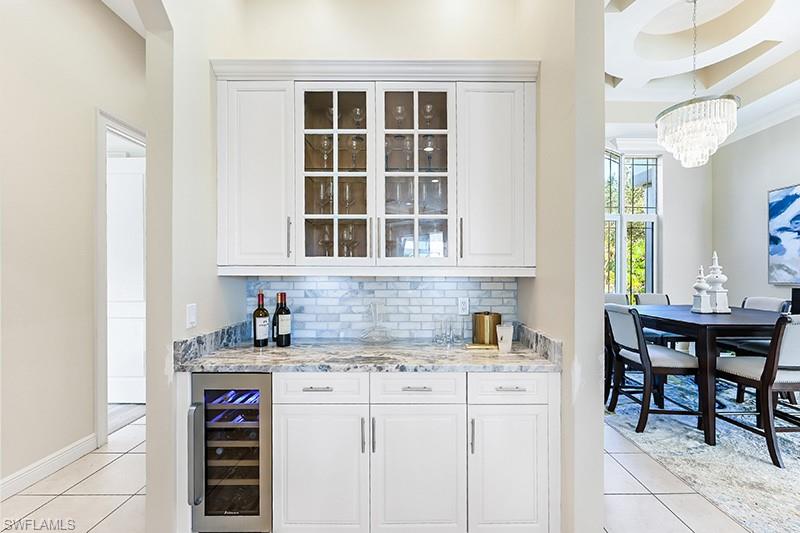 11234 5 Oaks Lane Naples, FL 34120 - Photo 11 of 34 a kitchen with stainless steel appliances granite countertop a sink and cabinets