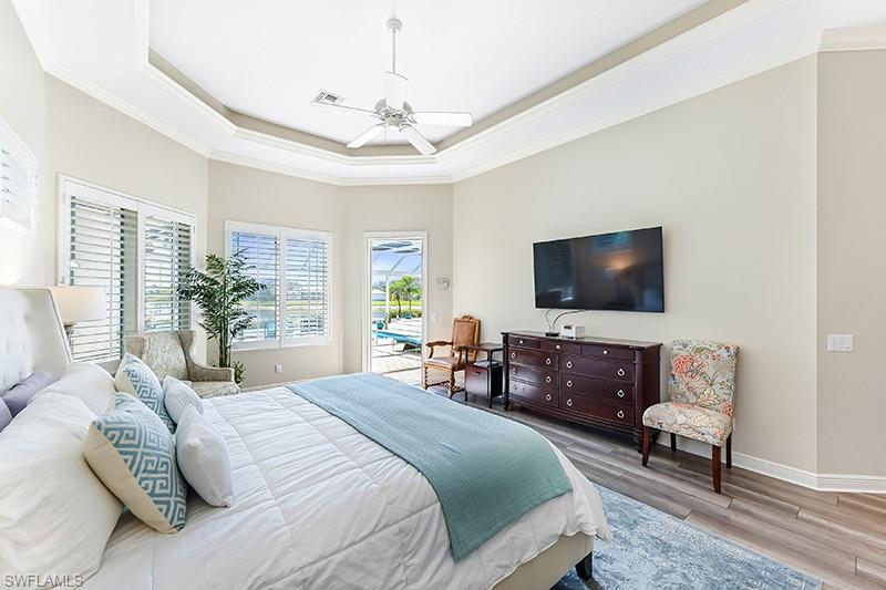 11234 5 Oaks Lane Naples, FL 34120 - Photo 13 of 34 a bedroom with a bed and a flat screen tv