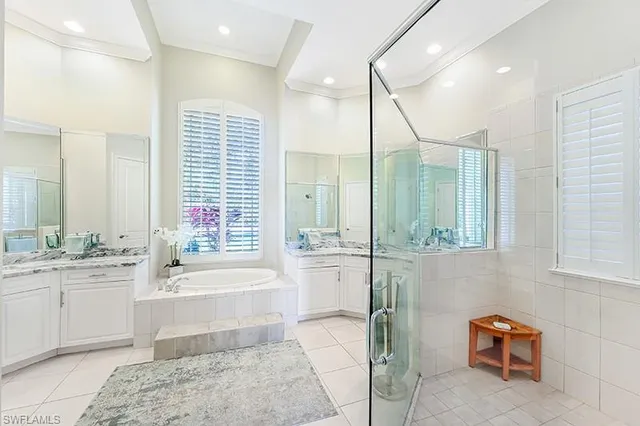 a bathroom with a tub a sink and a large mirror