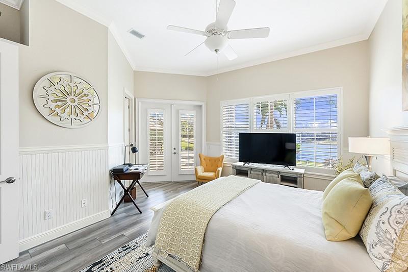 11234 5 Oaks Lane Naples, FL 34120 - Photo 15 of 34 a bedroom with a bed and a flat screen tv