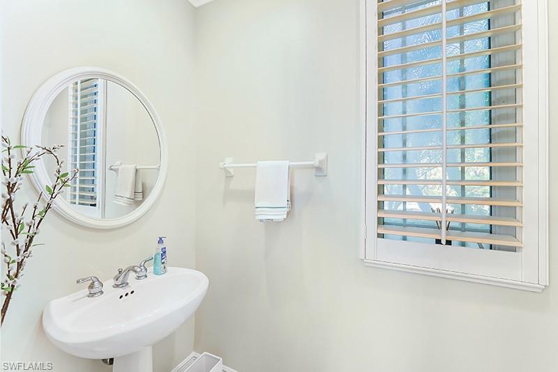 11234 5 Oaks Lane Naples, FL 34120 - Photo 18 of 34 a bathroom with a sink a mirror and shower