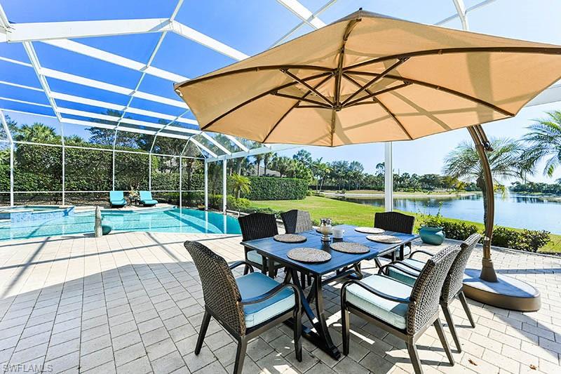 11234 5 Oaks Lane Naples, FL 34120 - Photo 19 of 34 a view of an outdoor sitting area with furniture and umbrella