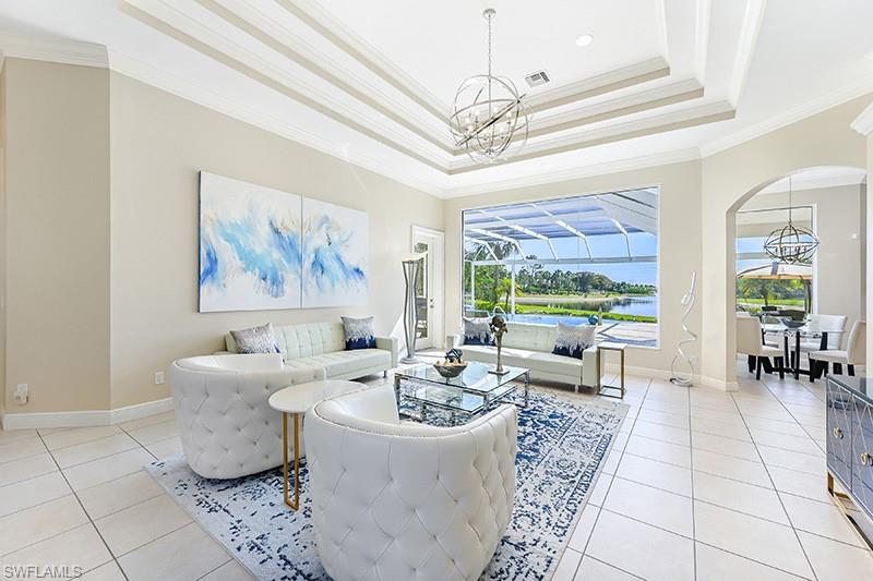 11234 5 Oaks Lane Naples, FL 34120 - Photo 2 of 34 a living room with furniture and a chandelier