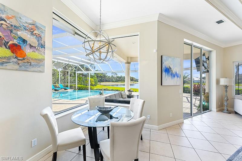 11234 5 Oaks Lane Naples, FL 34120 - Photo 8 of 34 a view of a dining room with furniture a chandelier and wooden floor