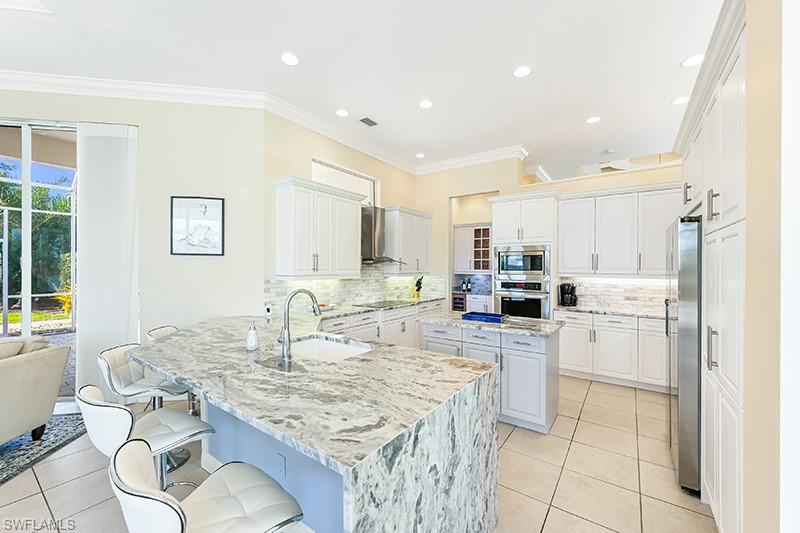 11234 5 Oaks Lane Naples, FL 34120 - Photo 10 of 34 a kitchen with kitchen island a sink counter top space and appliances