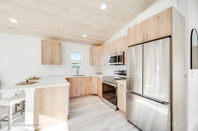 a kitchen with stainless steel appliances a refrigerator sink and stove