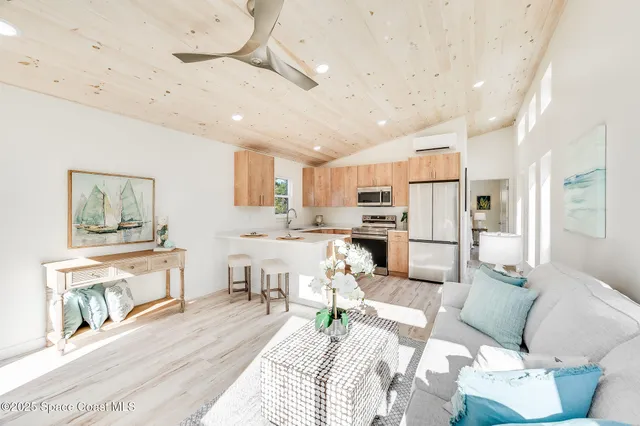 a kitchen with stainless steel appliances granite countertop a refrigerator oven a sink dishwasher and white cabinets with wooden floor