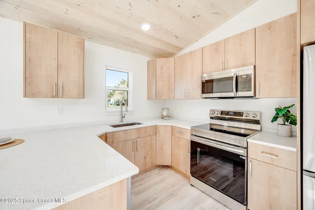 a kitchen with stainless steel appliances white cabinets and a stove top oven