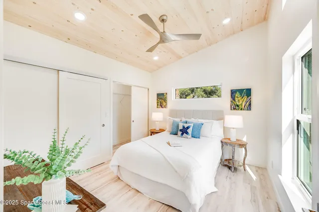 a bedroom with a large bed chandelier and a window