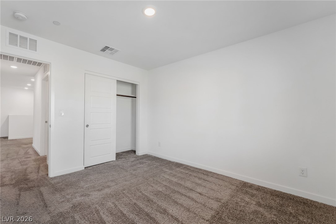 894 Cadence View Way Henderson, NV 89011 - Photo 20 of 23 Well-appointed bedroom featuring a neutral carpet and a functional closet for easy storage.