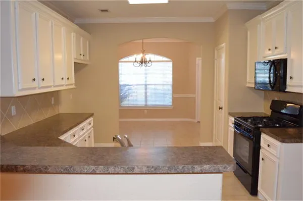 a kitchen with granite countertop a stove a sink and a granite counter tops