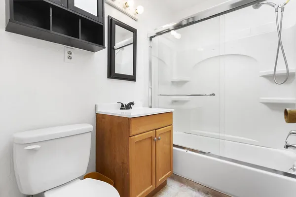 a bathroom with a sink a toilet and shower