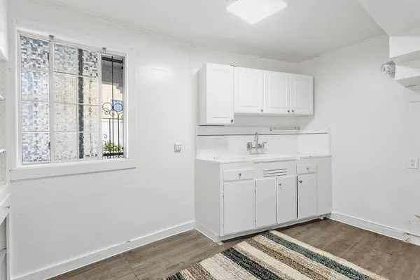 a view of a kitchen with white cabinets and a window