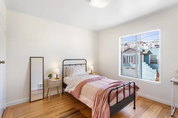 a bedroom with a bed and wooden floor