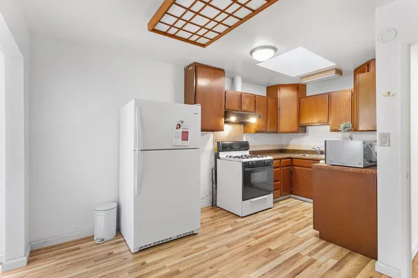 a kitchen with a refrigerator sink and wooden cabinets