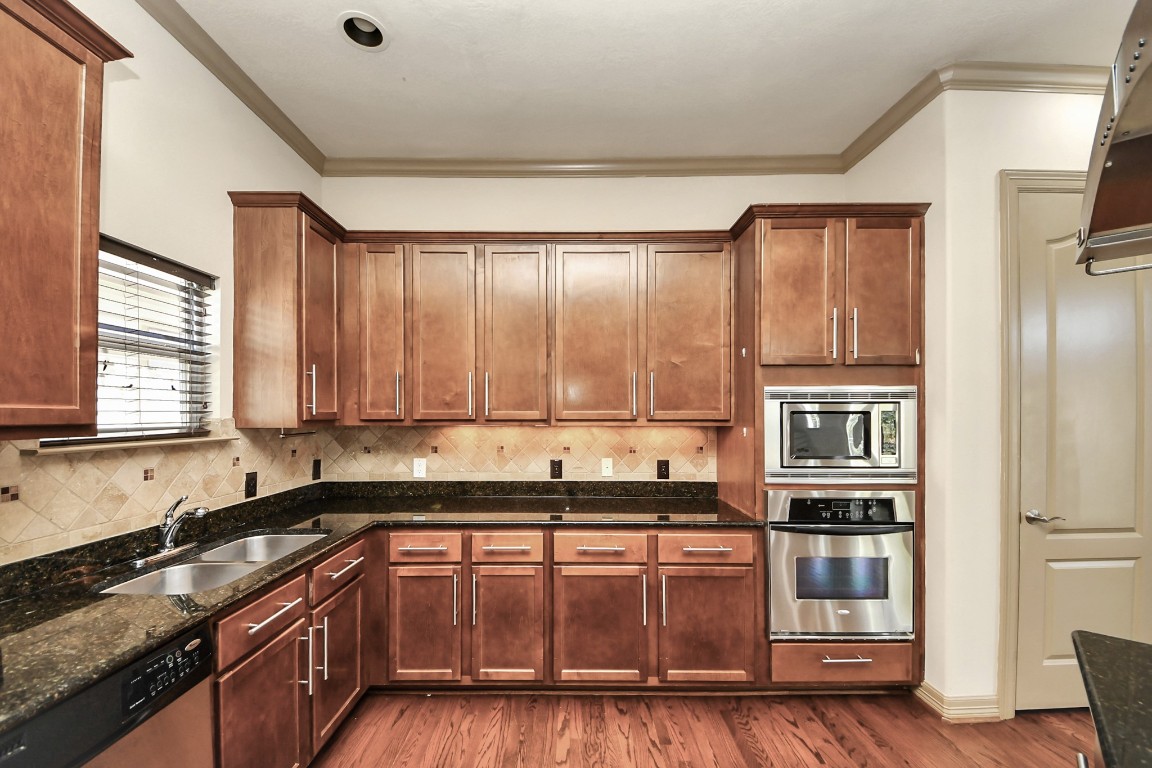 5711 Kiam Street Houston, TX 77007 - Photo 12 of 30 a kitchen with stainless steel appliances granite countertop a stove a sink and a refrigerator