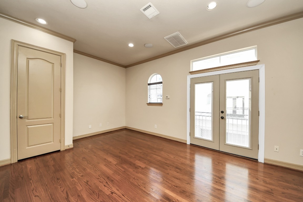 5711 Kiam Street Houston, TX 77007 - Photo 14 of 30 a view of an empty room with wooden floor and a window