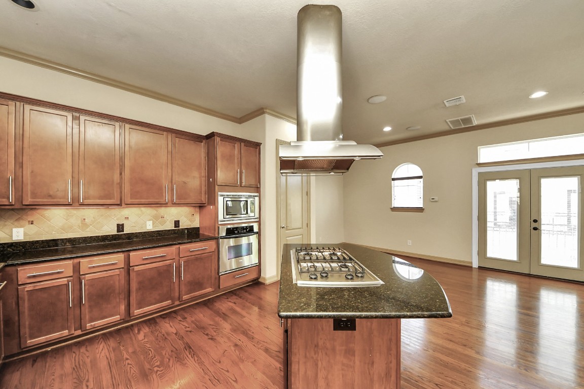5711 Kiam Street Houston, TX 77007 - Photo 3 of 30 a kitchen with stainless steel appliances granite countertop a sink stove and wooden floor