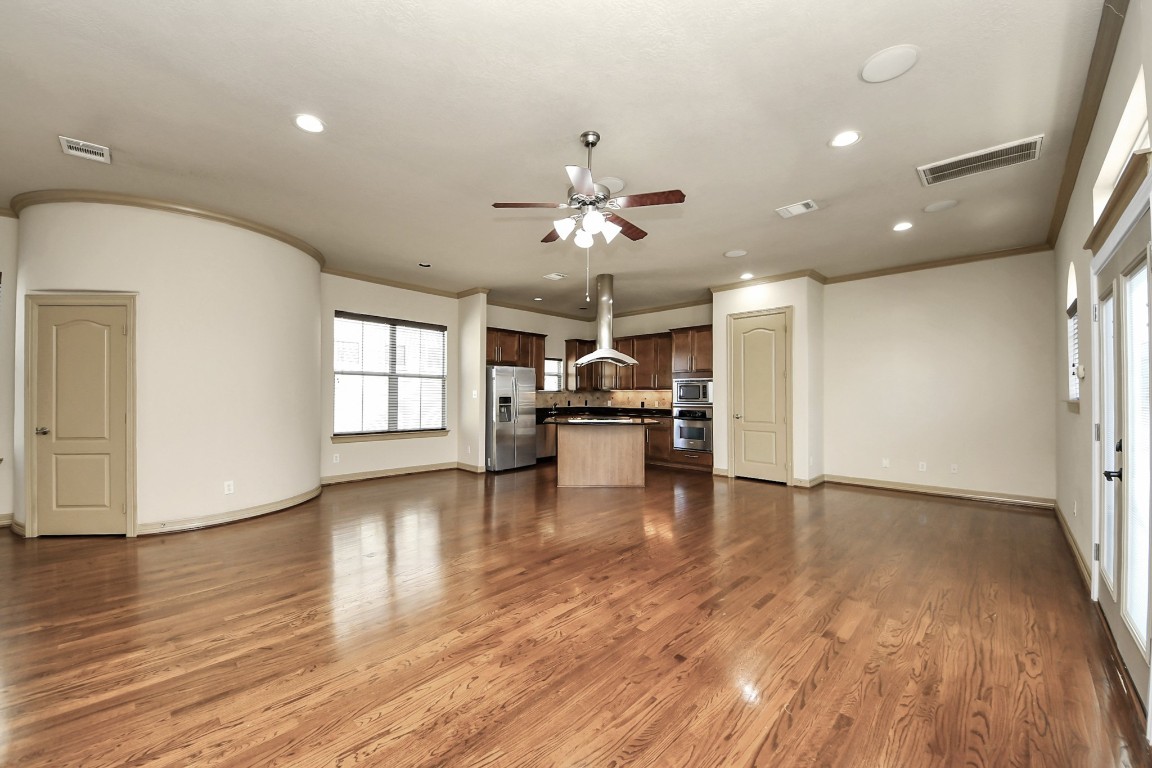 5711 Kiam Street Houston, TX 77007 - Photo 7 of 30 a view of a livingroom with a kitchen space a ceiling fan and wooden floor