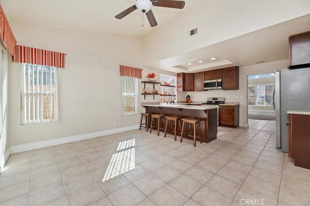 19966 Westerly Drive Riverside, CA 92508 - Photo 18 of 39 a kitchen with stainless steel appliances a refrigerator a stove a sink dishwasher with a dining table and chairs
