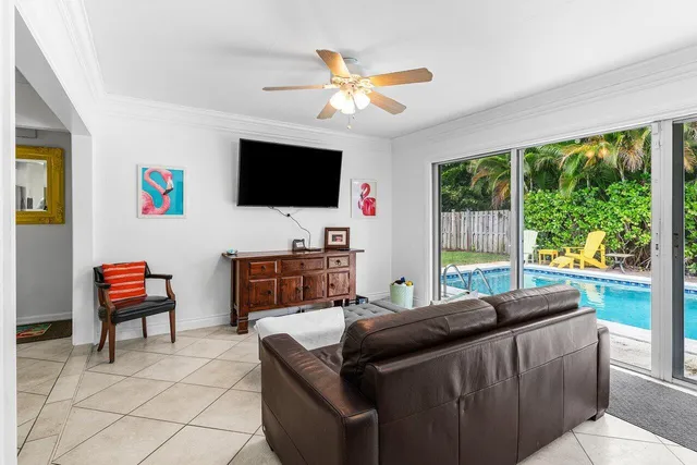 a living room with furniture a flat screen tv and a floor to ceiling window