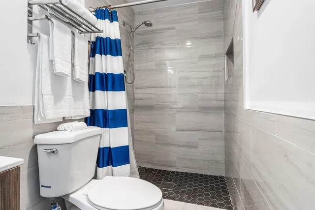 a bathroom with a sink a toilet and shower