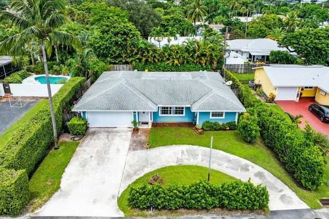 an aerial view of a house with swimming pool and garden