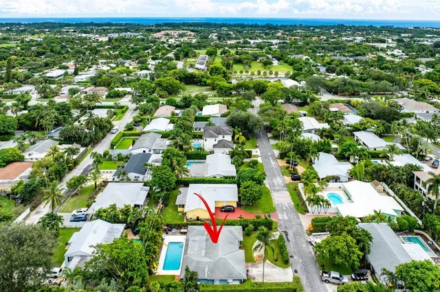 an aerial view of residential houses with outdoor space and trees