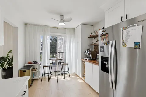 a view of a kitchen with refrigerator and furniture