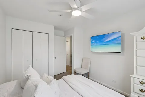 a bedroom with a bed and a ceiling fan
