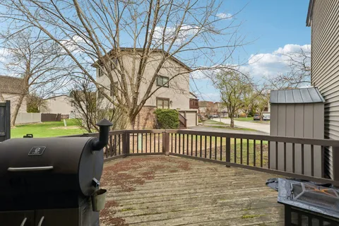 a view of backyard with deck and wooden fence