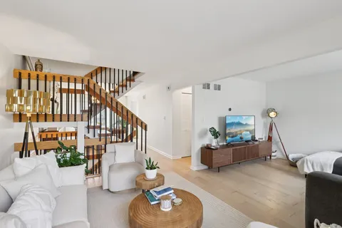 a living room with furniture and wooden floor