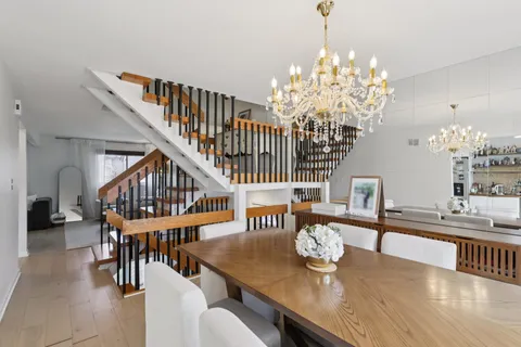 a dining room with furniture a chandelier and wooden floor