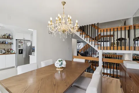 a dining room with furniture a chandelier and wooden floor