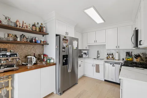 a kitchen with refrigerator a stove a sink and cabinets