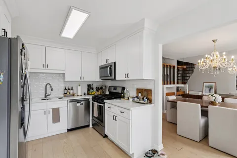 a kitchen with white cabinets and white appliances