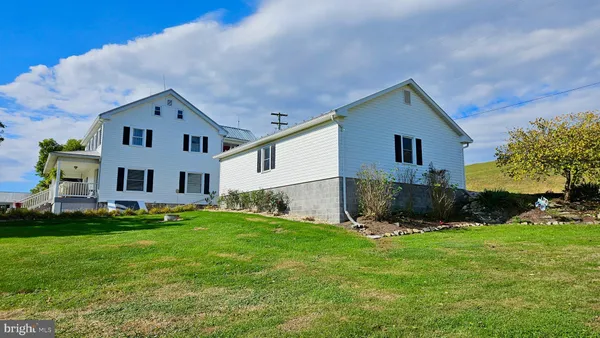 a view of a house with a yard and sitting area