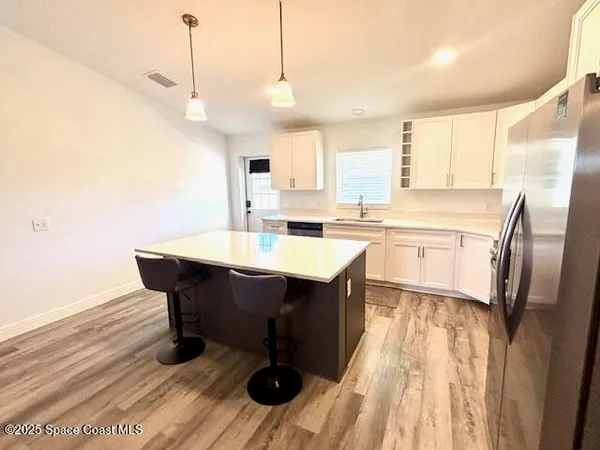 a kitchen with a sink a stove a dining table and chairs