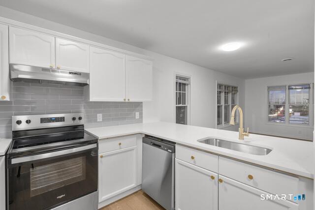 468 Main Street, Unit 318 East Lyme, CT 06357 - Photo 20 of 33 a kitchen with stainless steel appliances granite countertop a sink stove and cabinets