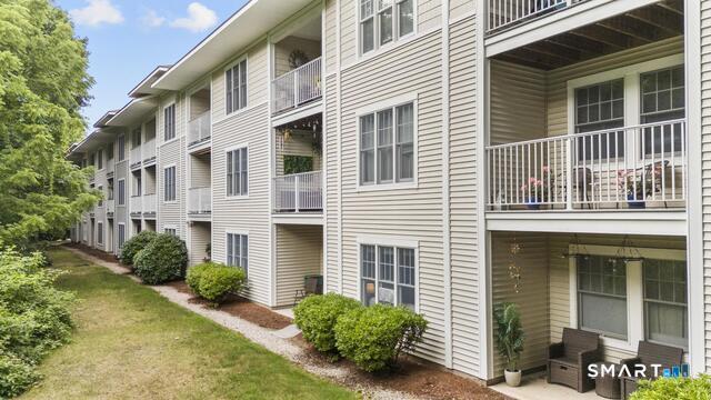 468 Main Street, Unit 318 East Lyme, CT 06357 - Photo 2 of 33 a view of a house with a small yard and plants
